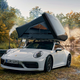 A photo of a roof top tent on the top of a Porsche 911.